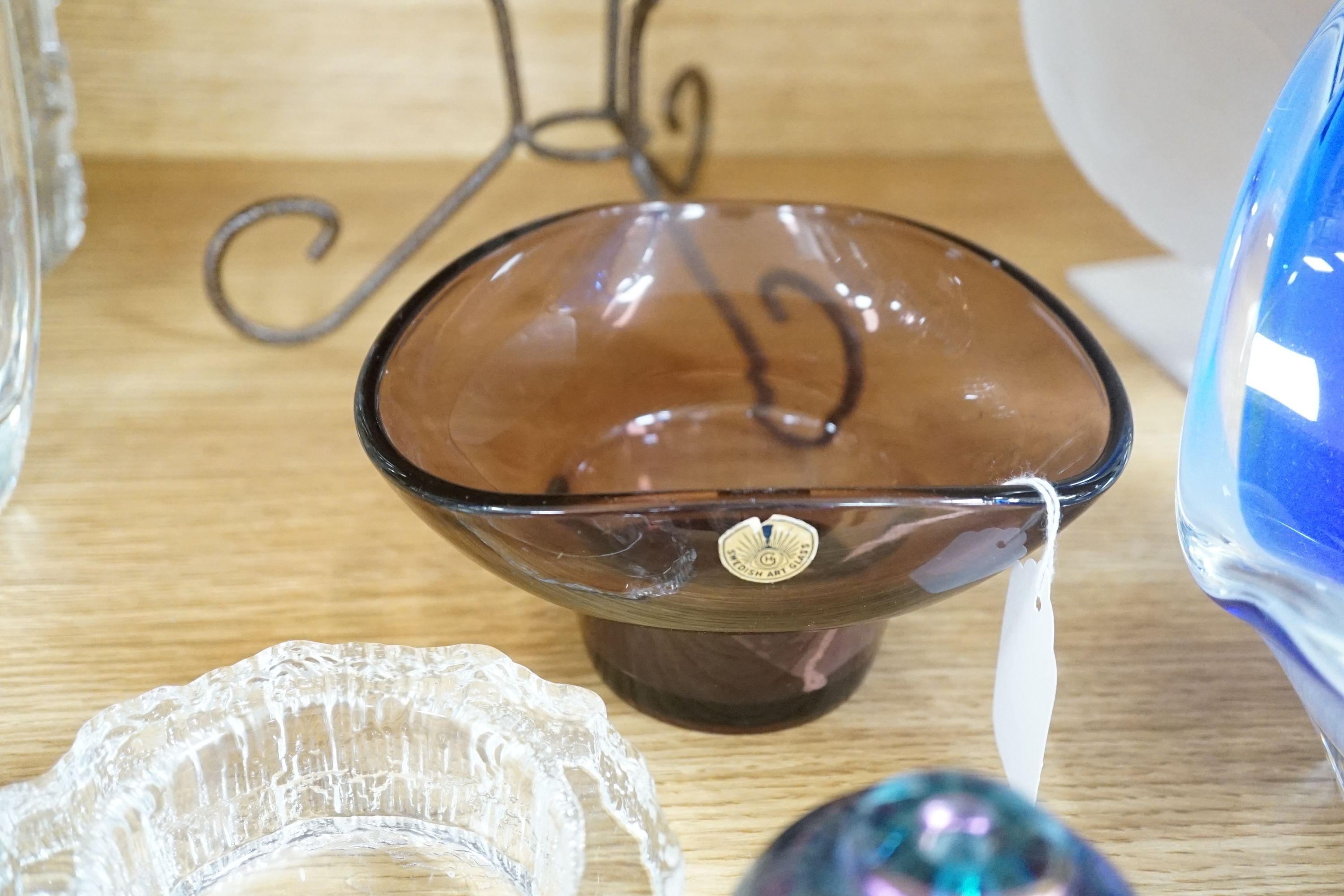 A frosted art glass bowl on stand with ‘face’ pattern to base together with an Iitalla map ash tray designed by Tapio Wirkkala, a bohemian iron and spatter pattern glass shade oil lamp, Tom Philabaum art glass perfume bo